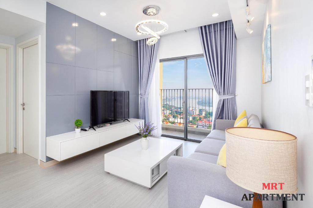 uma sala de estar com um sofá e uma televisão em MRT Apartment In Masteri Thao Dien em Ho Chi Minh