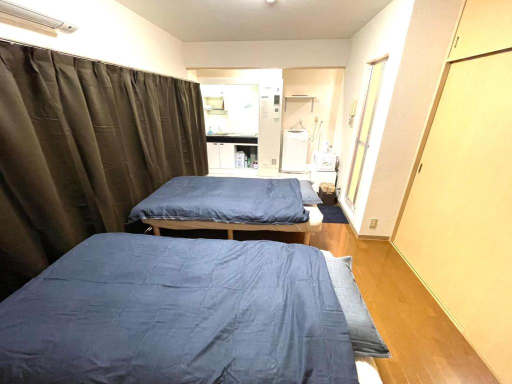 two beds in a hospital room with curtains at Tokyo Stay Waseda in Tokyo