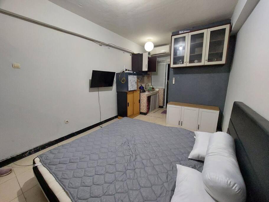 Habitación pequeña con cama y cocina en Apartemen Casablanca East Residence, en Yakarta