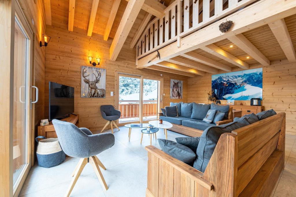 a living room with a blue couch and a table at Chalet du Tricot - Vue sur le Mont Blanc in Saint-Gervais-les-Bains