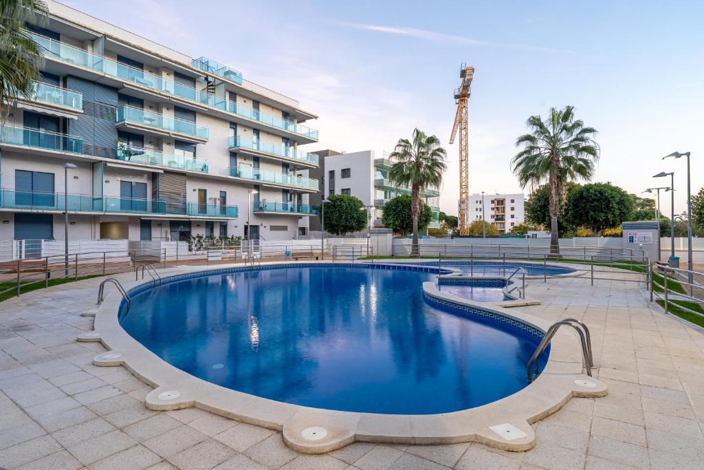 a swimming pool in front of a building at Cambrils Platja in Cambrils