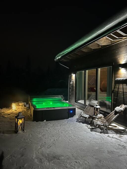 a pool in the snow next to a house at Silencius Cabin With Private Jacuzzi in Rovaniemi