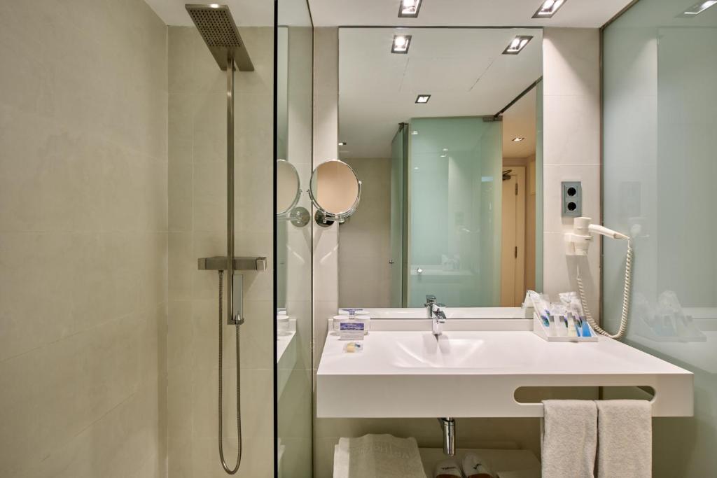 a bathroom with a sink and a shower with a mirror at VP Madroño in Madrid