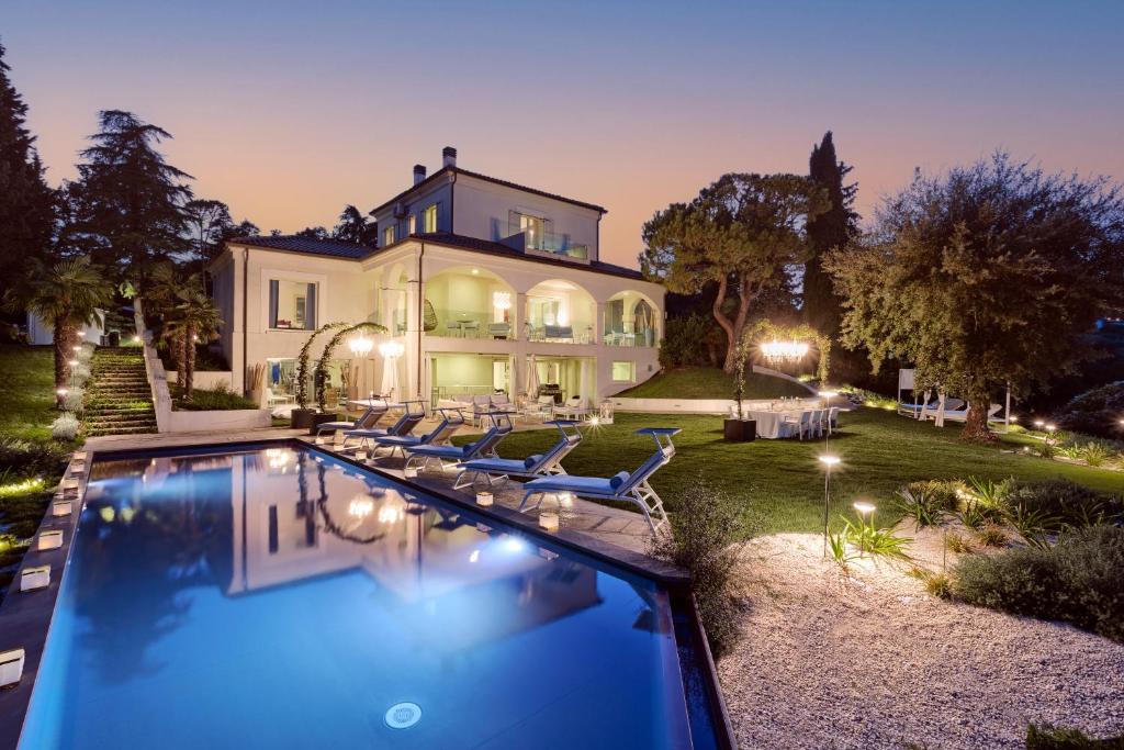 a large house with a swimming pool in front of it at Villa Belvedere in Bertinoro