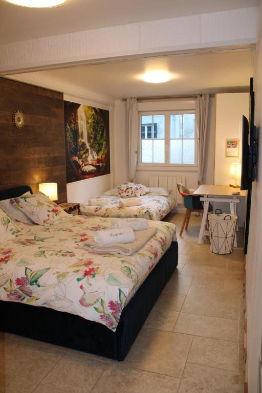 a bedroom with two beds and a table in it at Résidence Loanie & Soins in Châlus