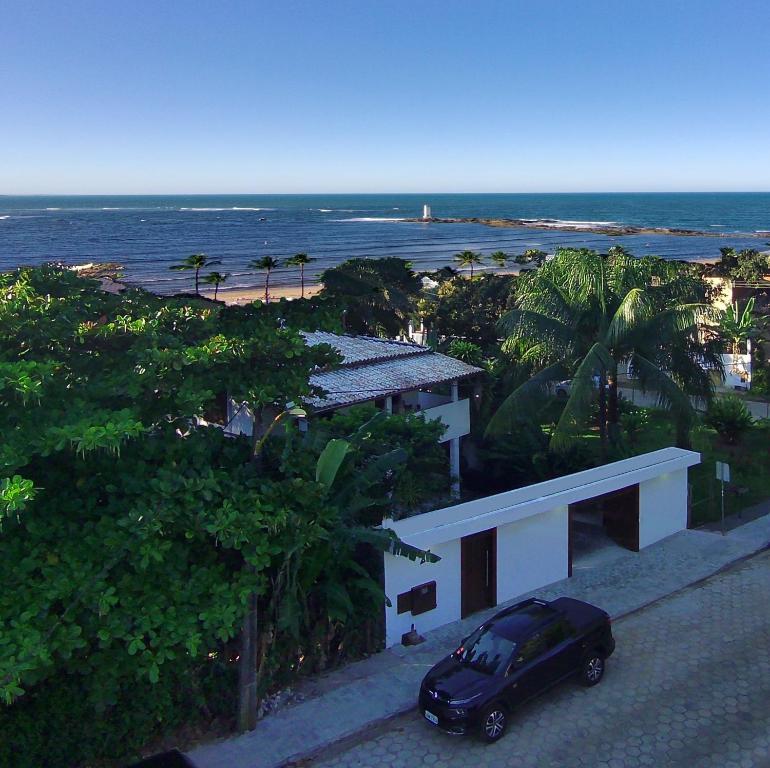 a black car parked in front of a house with the beach at Residência Thomas in Itacaré