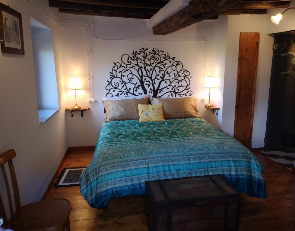 a bedroom with a bed with a tree mural on the wall at Col di Lana in Rocca di Botte