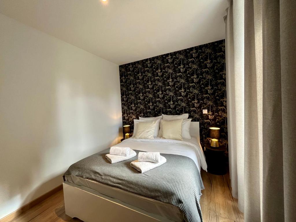 a bedroom with a bed with two towels on it at LesCinqSuites / Le Chivas - DABNB in Limoges