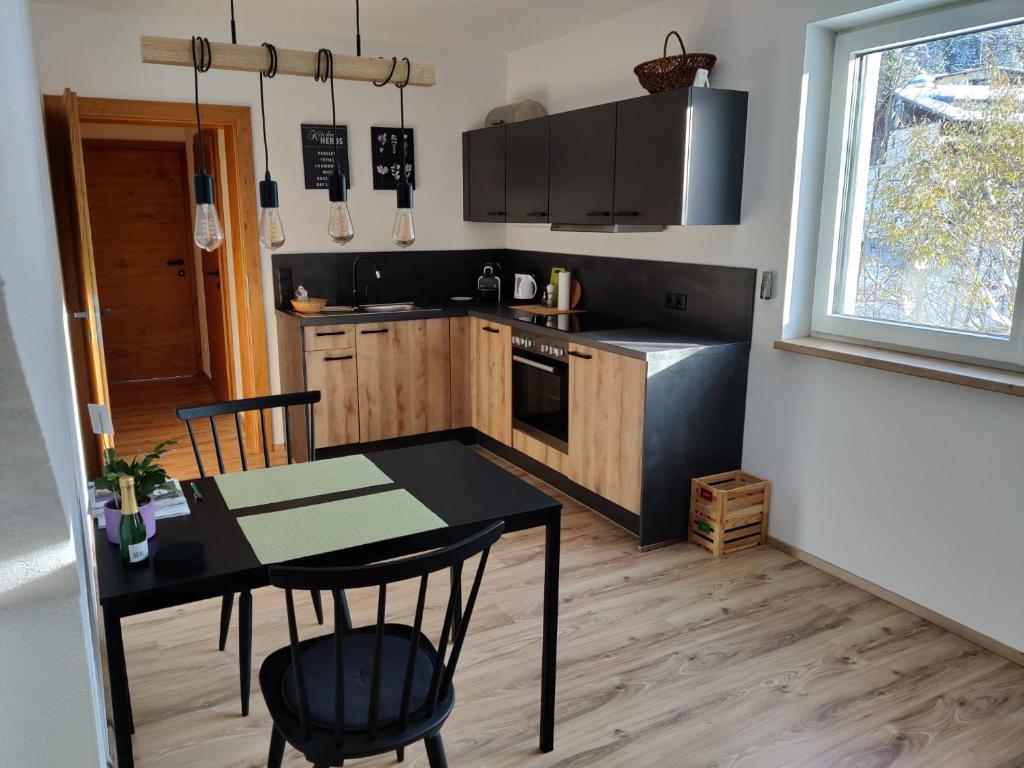 a kitchen with a table and a table and chairs at Apartment am Mühlbach in Reith bei Seefeld