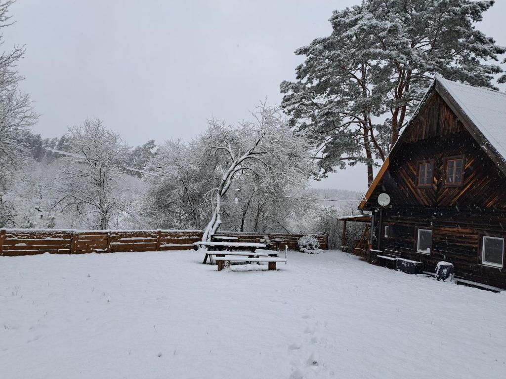 una baita nella neve con un tavolo da picnic di Chatka Kurki a Kurki