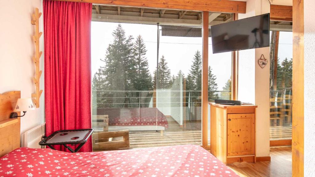 a bedroom with a bed and a large window at V du Bachat EPICEA C02 - Appt 5 pers in Chamrousse