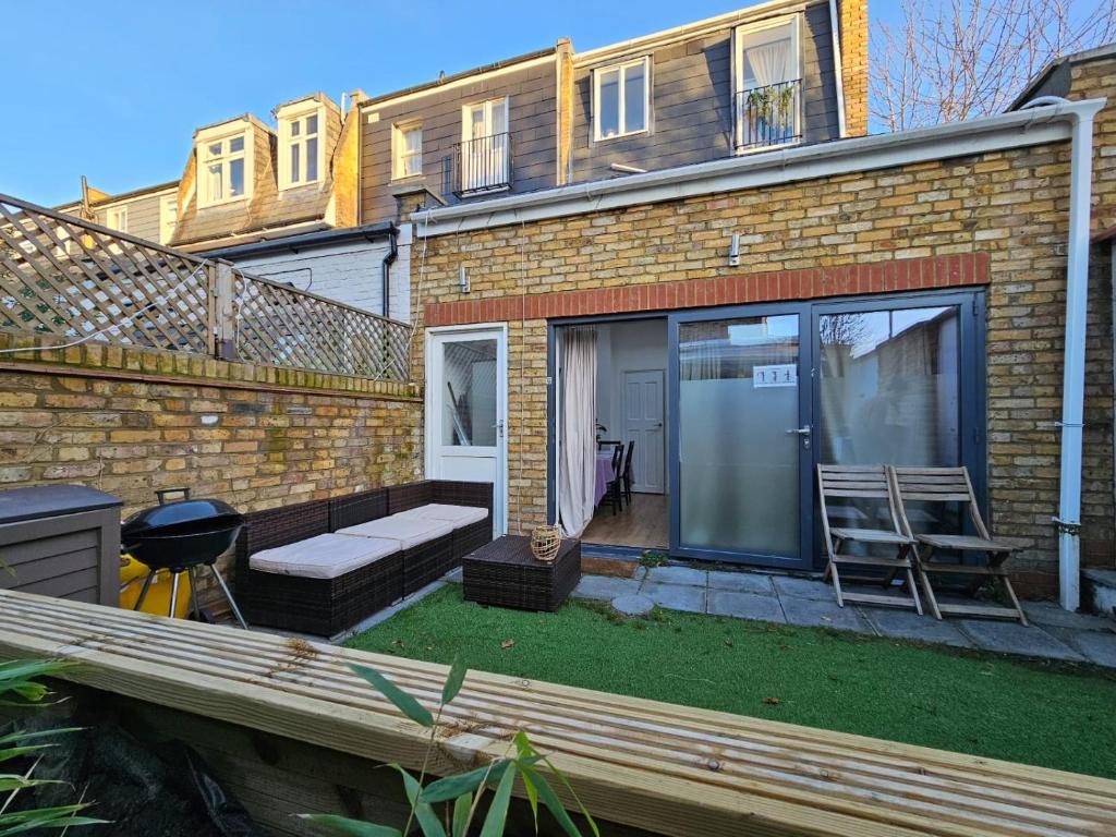 ein Backsteinhaus mit einer Bank und einer Terrasse in der Unterkunft Putney Thames garden flat in London