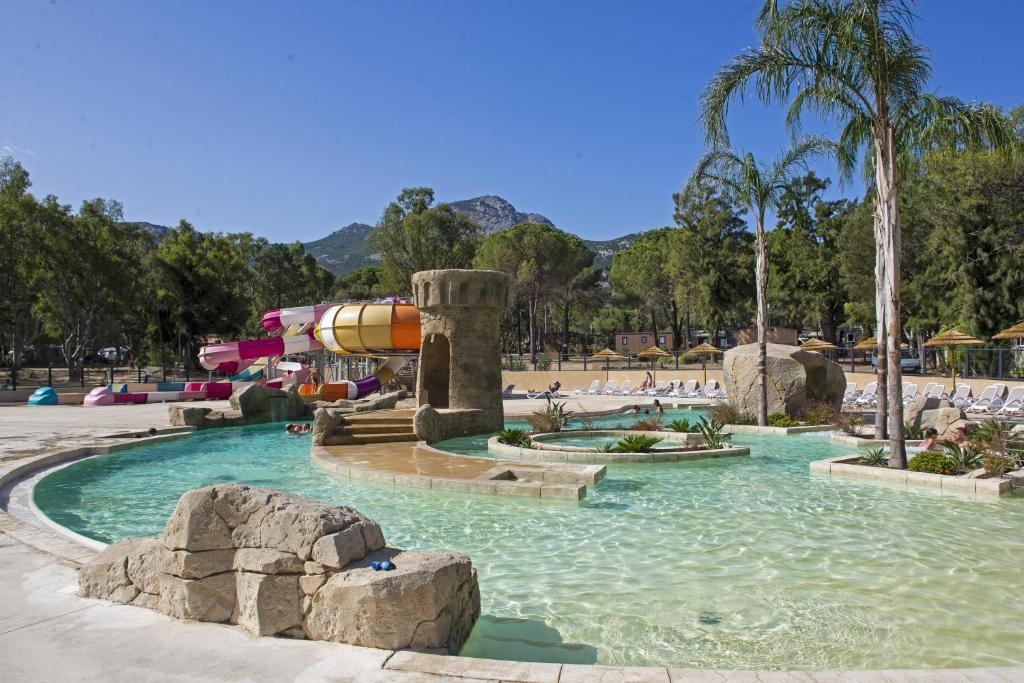 Camping Bella Vista في كالفي: حديقة مائية بها مسبح وزحليقة مائية