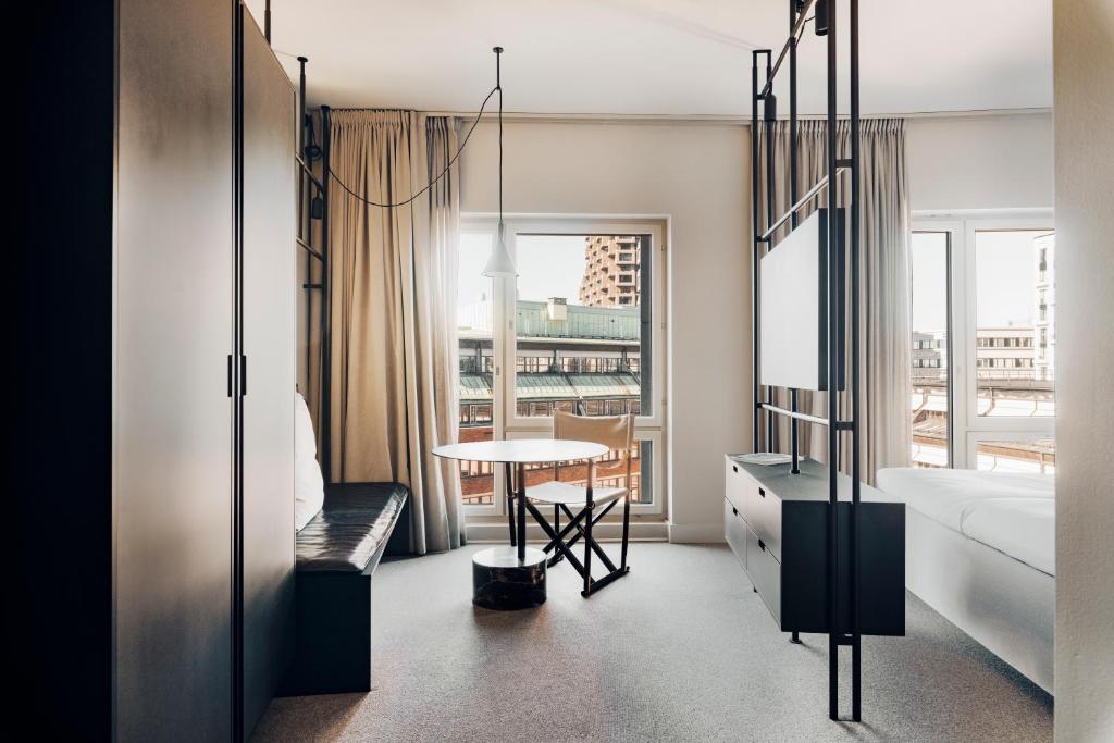 una camera con letto, tavolo e finestra di Blique by Nobis, Stockholm, a Member of Design Hotels™ a Stoccolma