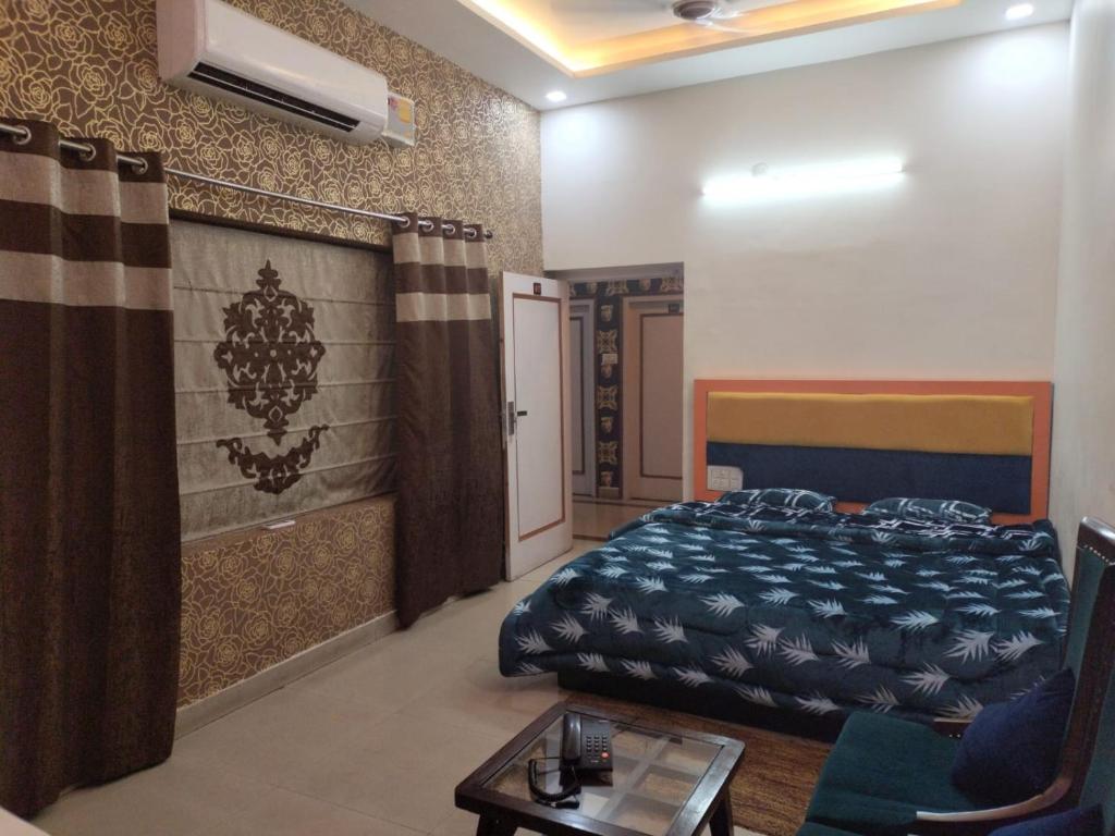 a bedroom with a bed and a couch and a table at Hotel Rainbow in Yamunānagar