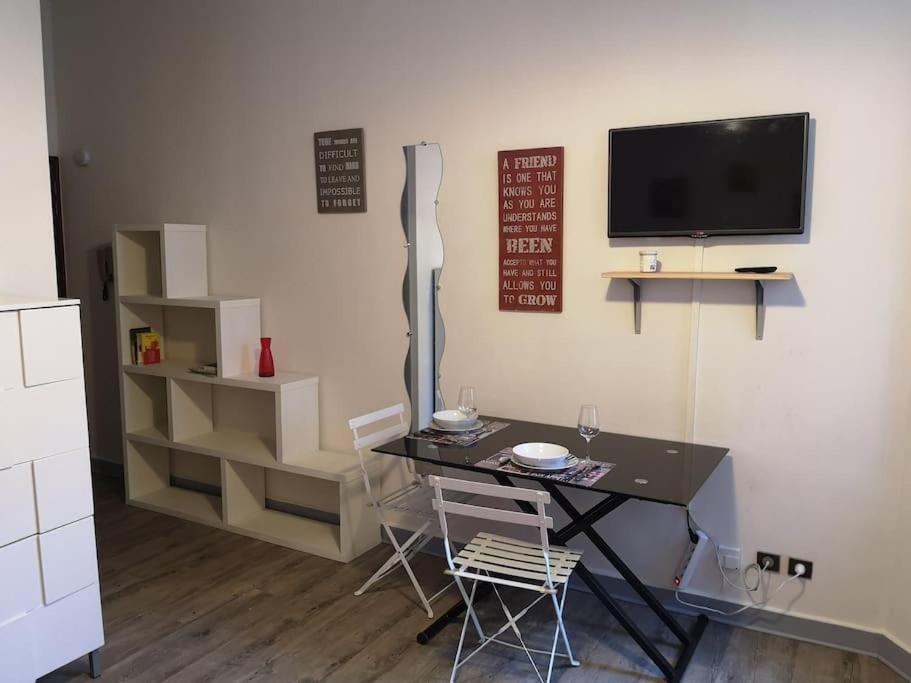 une salle à manger avec une table et des chaises et une télévision dans l'établissement LE PETIT BESSE - Calme - Centre Ville - Thermes, à Vichy