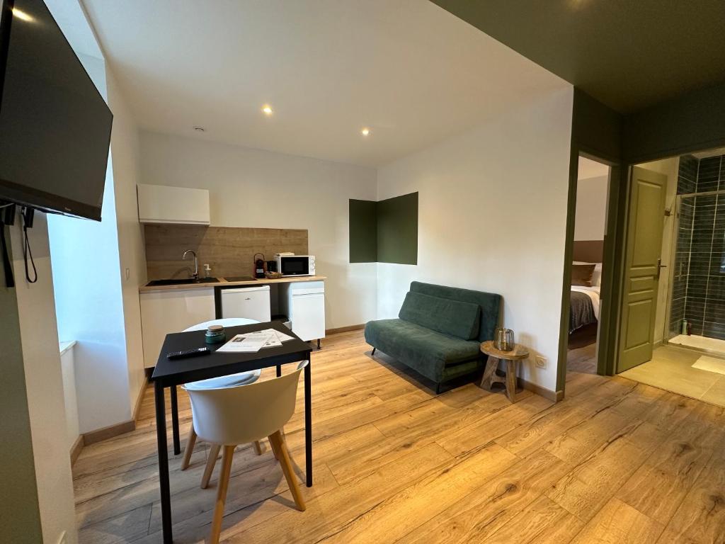 ein Wohnzimmer mit einem Tisch und einem grünen Stuhl in der Unterkunft Limoges Sud-LesCinqSuites Le Saint Laurent-DABNB in Limoges
