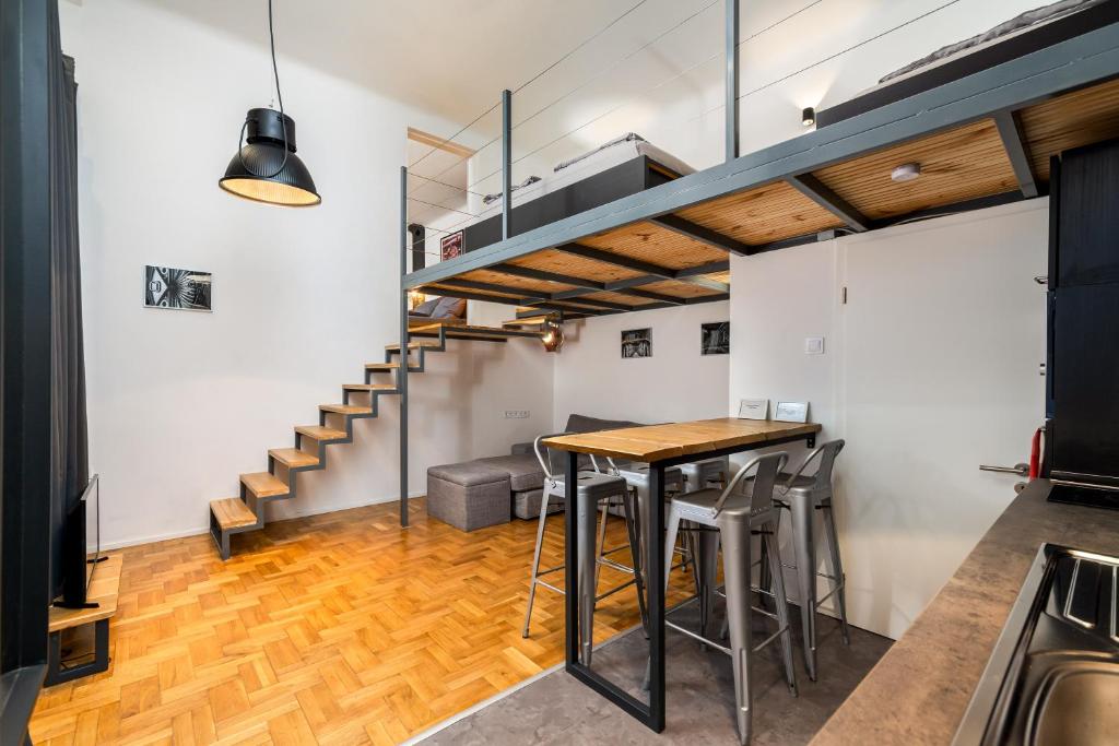 uma sala de jantar com uma mesa e uma escada em Industrial Westend em Budapeste