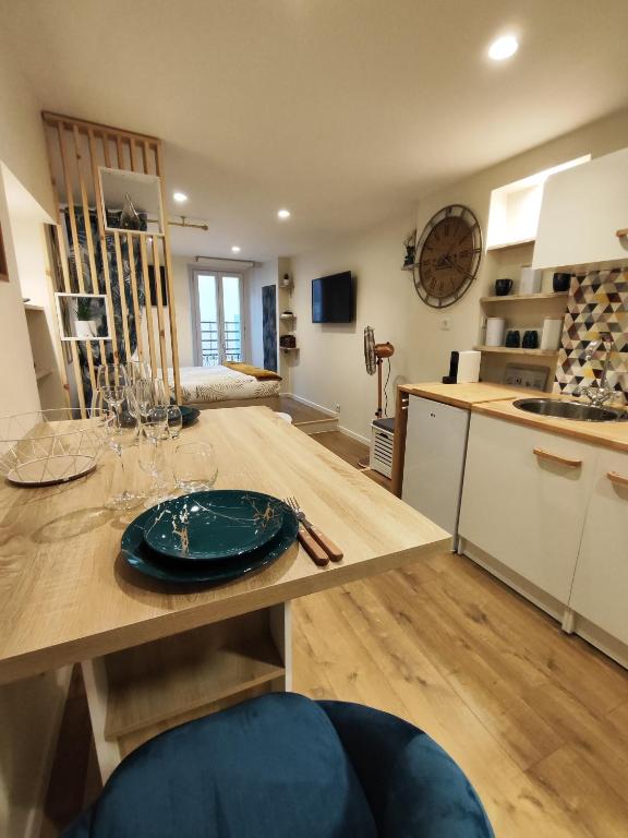 une cuisine avec une table en bois et une plaque de cuisson. dans l'établissement Studio vieille ville tout équipé sans ascenseur, à Menton