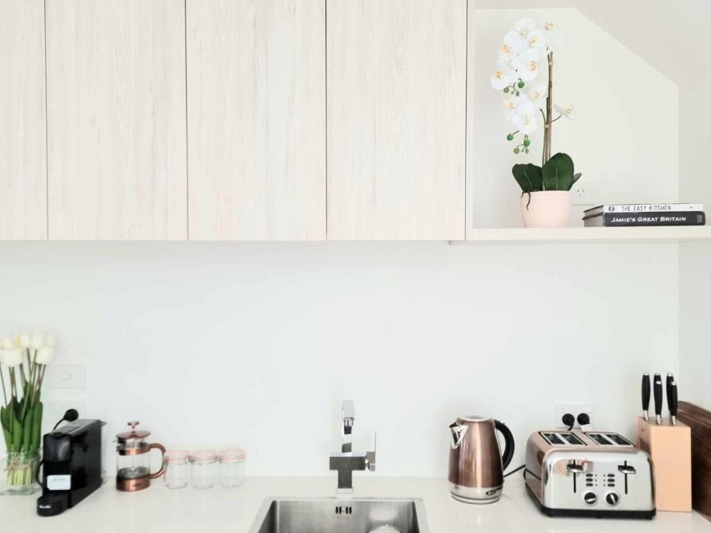 a kitchen counter with a sink and a counter top with a sink at Elegant CBD Apartment in Christchurch