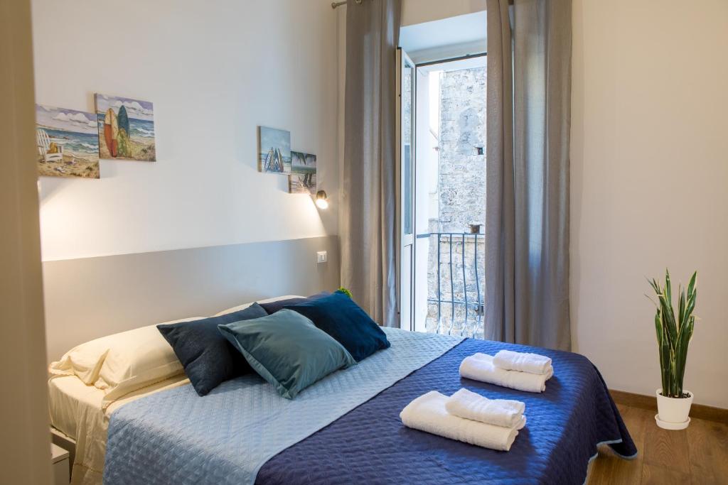 a bedroom with two towels on a bed with a window at Teatro Romano Centro Storico Wi-FI Centralissima in Terracina