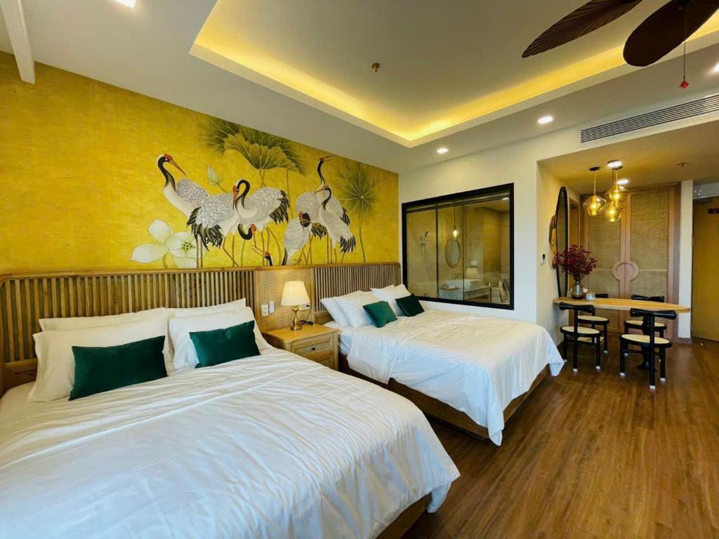 um quarto de hotel com duas camas e uma mesa com cadeiras em ST Apartment - FLC SeaTower Quy Nhon em Quy Nhon