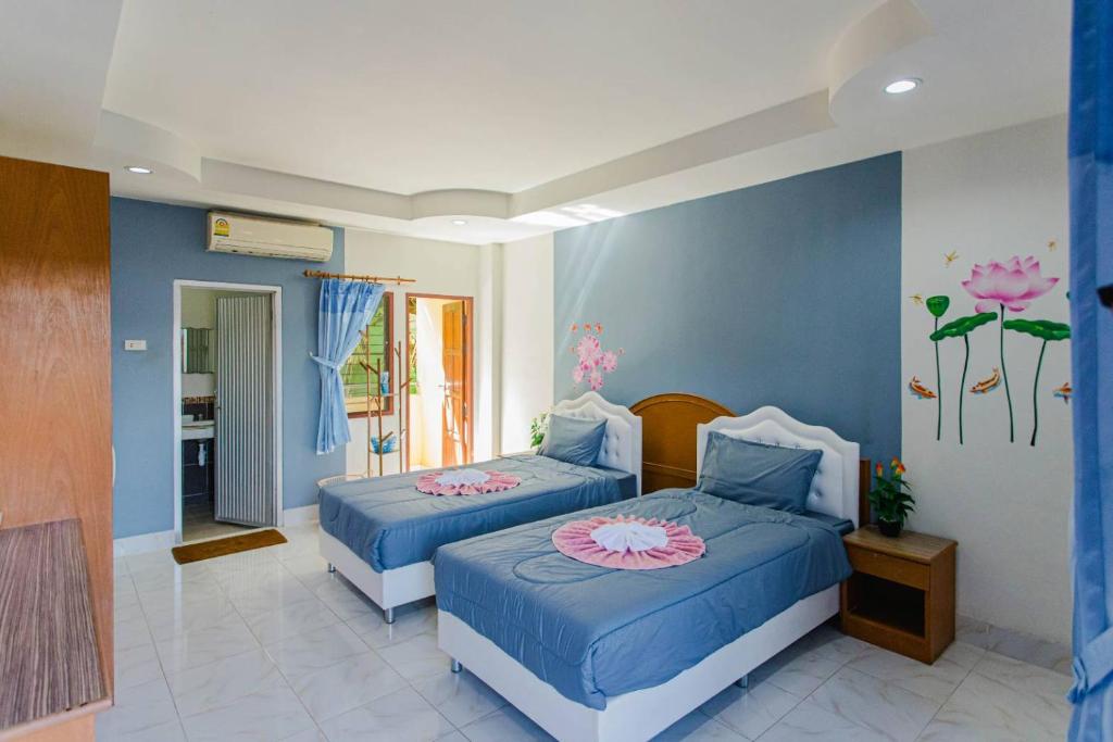 a bedroom with two beds with flowers painted on the wall at Pailin Hill Hotel in Patong Beach