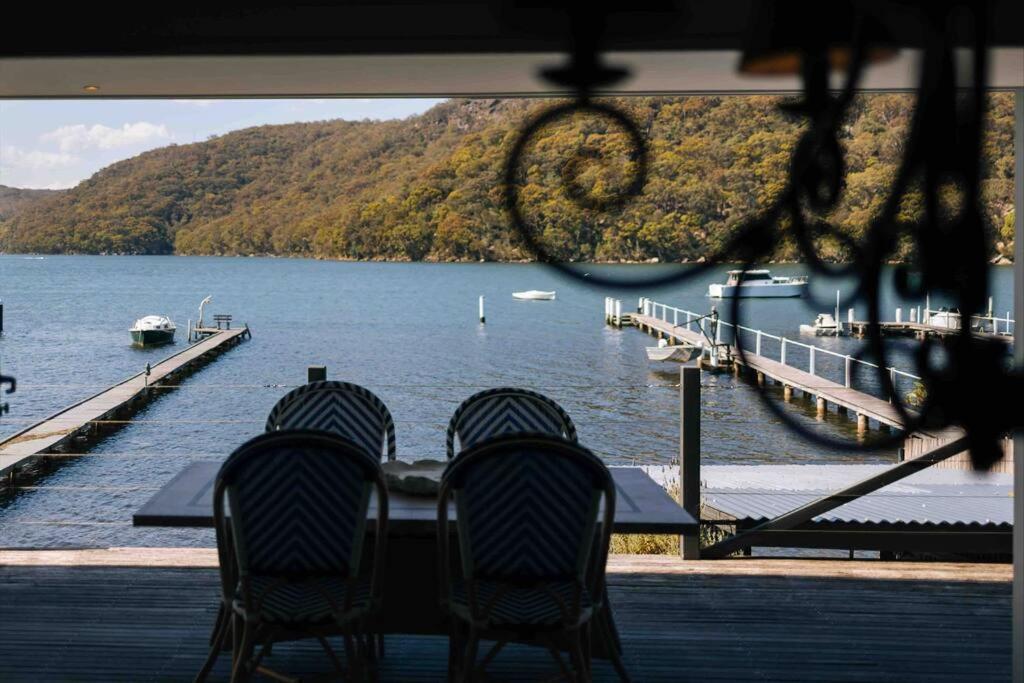 a group of chairs sitting at a table near the water at Private Jetty Kayaks Pets allow WoyWoy Bay in Woy Woy