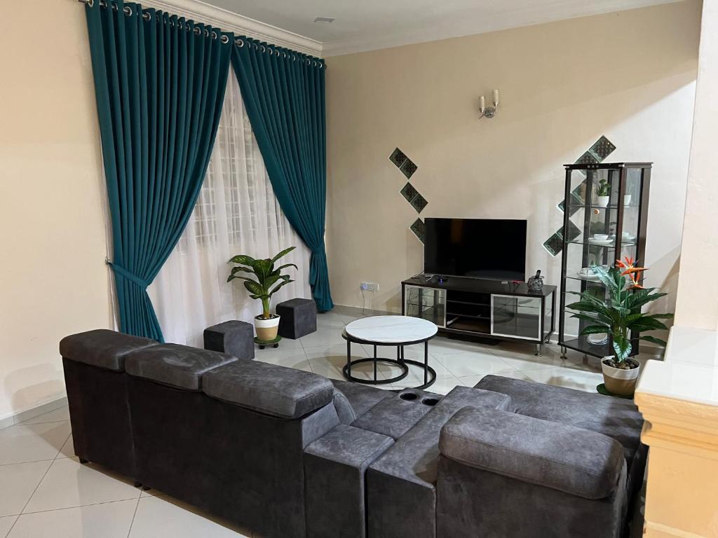 een woonkamer met een bank en een tafel bij Mutiara Villa Homestay - Comfort Away From Home in Merlimau