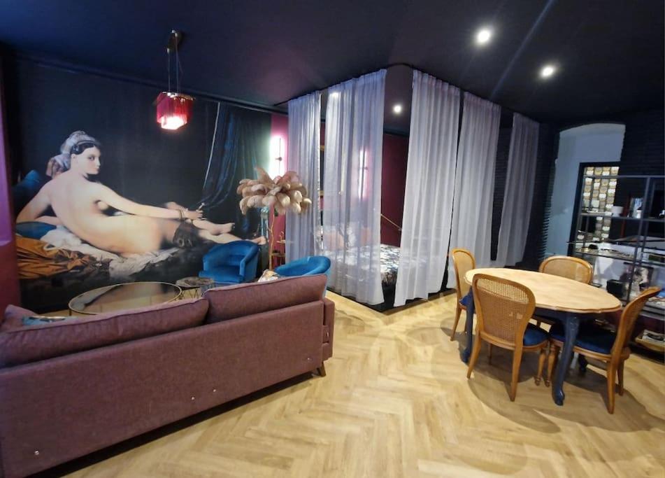 ein Wohnzimmer mit einem Sofa und einem Tisch in der Unterkunft Le Boudoir D'Olympe Appartement érotico-romantique in Montauban