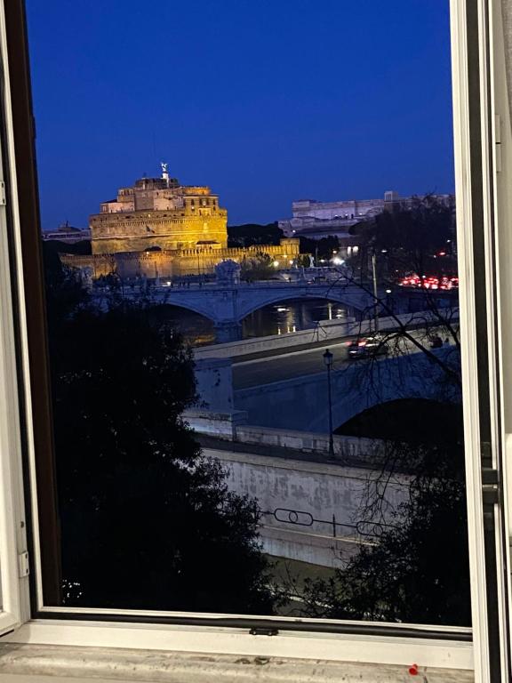 una ventana con vistas a un puente por la noche en Casa Della Rovere, en Roma