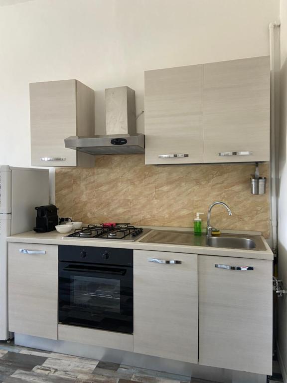 Biała kuchnia z kuchenką i zlewem w obiekcie Casa Della Rovere w Rzymie
