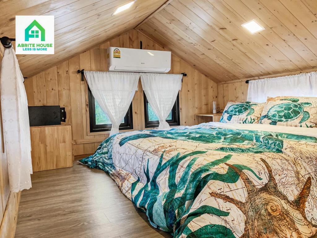 a bedroom with a bed in a wooden cabin at Tiny house on Koh Lanta only 2 minutes walk to the beach in Ban Mo Nae