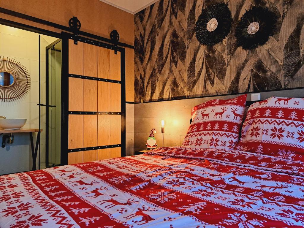 a red bed with red pillows in a bedroom at Gîte Chez Simone in Houffalize