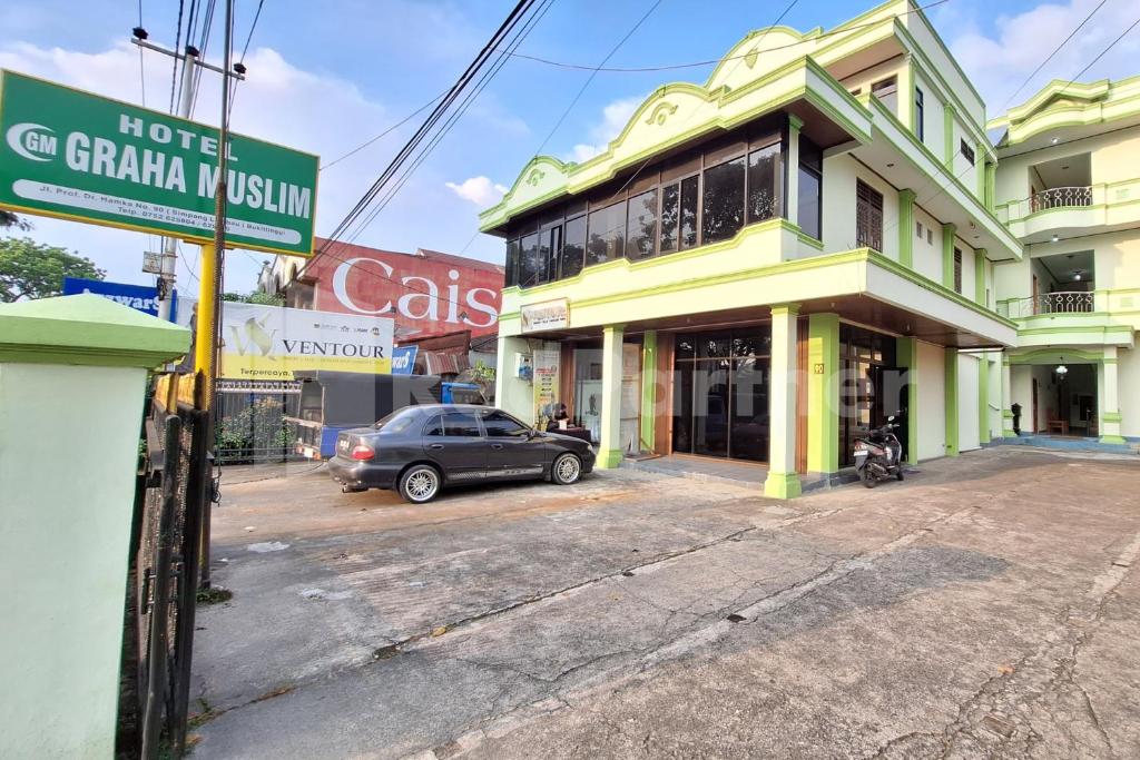 a car parked in front of a building at Hotel Graha Muslim RedPartner in Bukittinggi