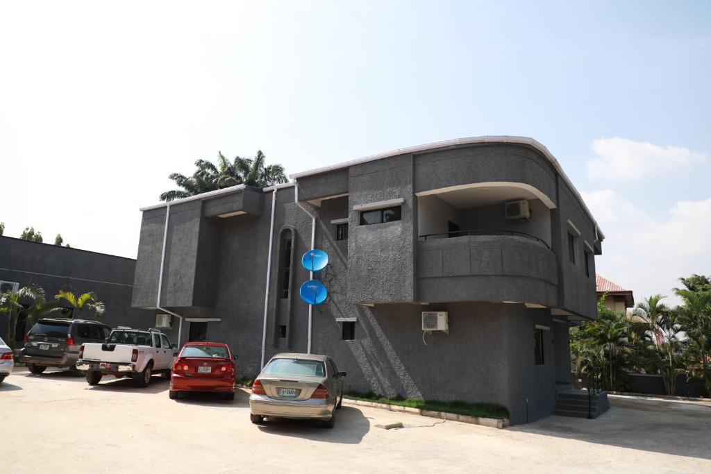 a building with cars parked in a parking lot at D & D Apartments in Abuja