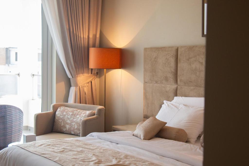 1 dormitorio con 1 cama y 1 silla junto a una ventana en Lamer villa en Al Ashkharah