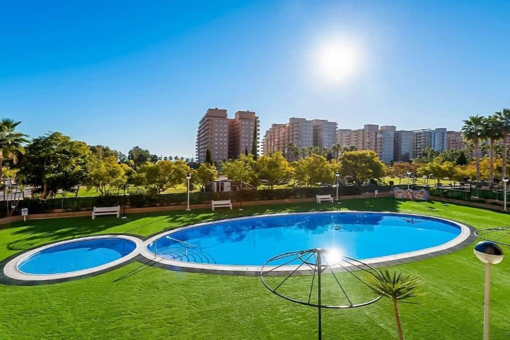 a large swimming pool in a park with a city at Apartamento Costa Marina II REF. 020 in El Borseral