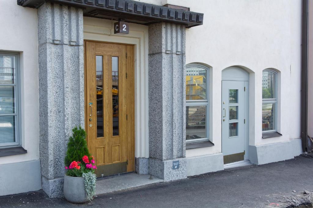 um edifício com uma porta de madeira e flores na frente em Chic Studio in Historic Kruununhaka, Helsinki em Helsinque