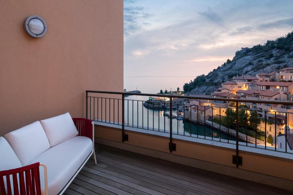 balcón con sofá y vistas al agua en Portopiccolo Apartments - Appartamento Perla nel borgo, en Sistiana