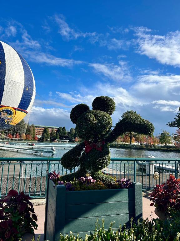 une statue d'ours en peluche dans un planteur devant une rivière dans l'établissement Jolie chambre 3minutes de la Gare RER A, à Bussy-Saint-Georges