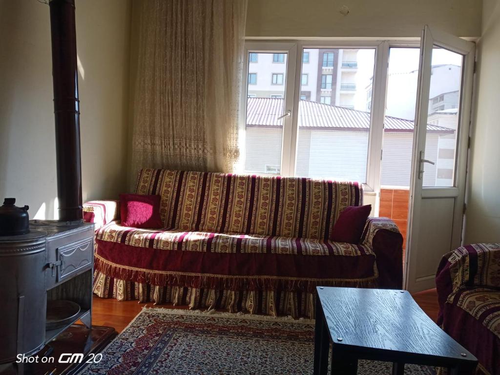 a living room with a couch and a large window at Tatvan Merkezde Sahile Yakın Eviniz in Tatvan