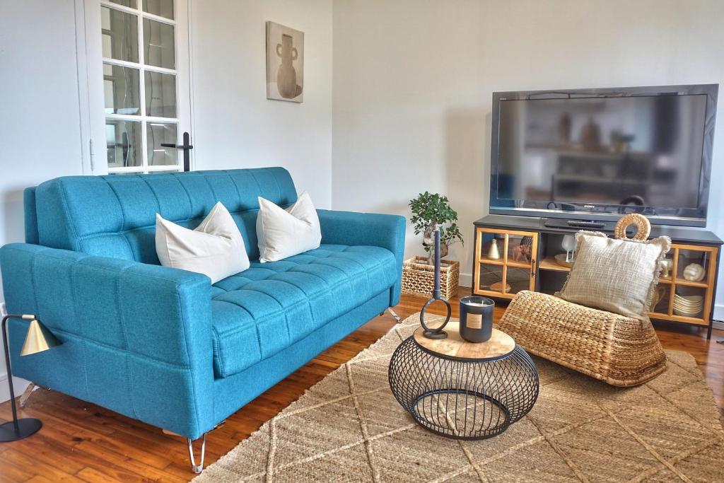 a blue couch in a living room with a tv at Maison cosy proche de la mer in Binic