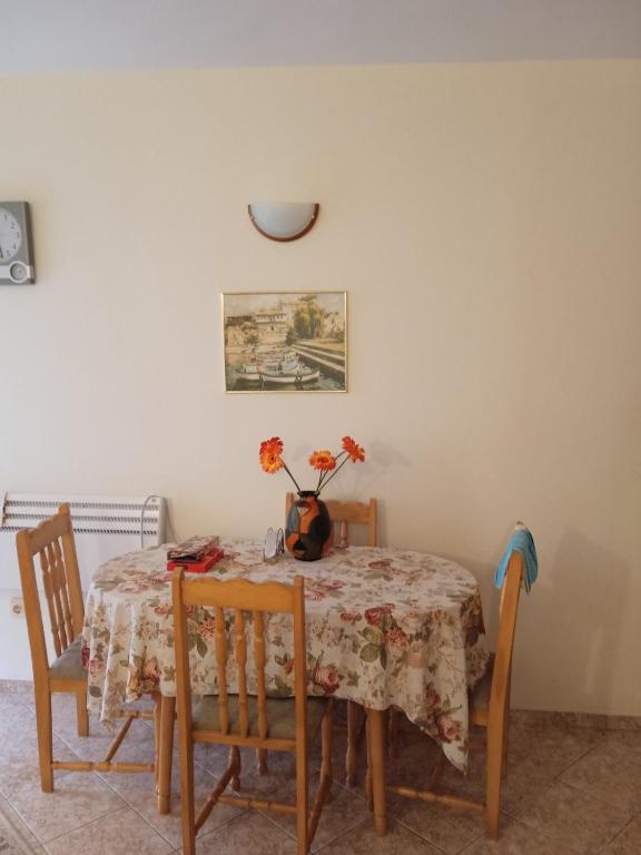 a dining room table with a vase of flowers on it at Rutland Bay in Ravda