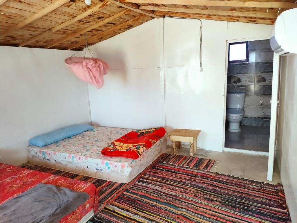 een kleine kamer met een bed en een raam bij Casablanca Beach Camp in Nuweiba‘ el Muzeinah