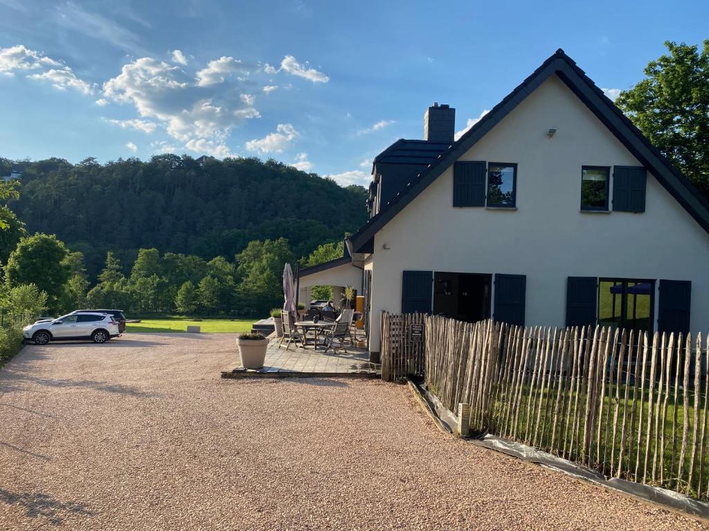 a white house with a fence and a car at Studio & Appartement au Lac in Sart-lez-Spa