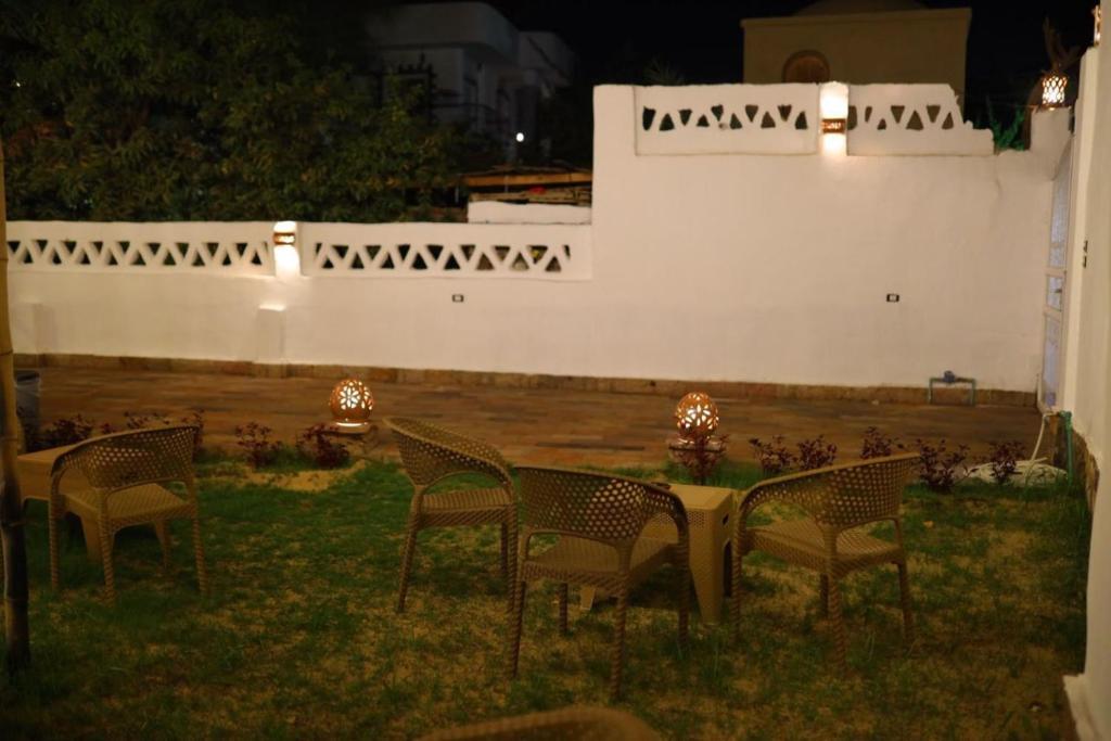 a group of chairs sitting in a yard at night at Diamond Guest House in Luxor