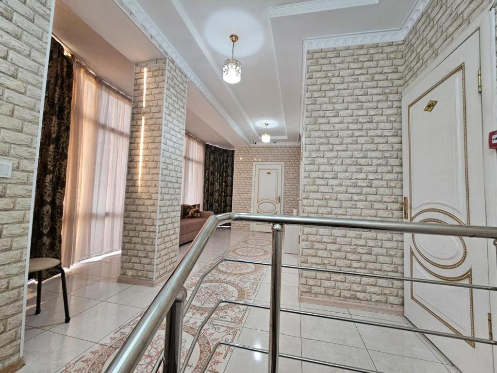 a hallway with a staircase and a brick wall at Lux in Türkistan