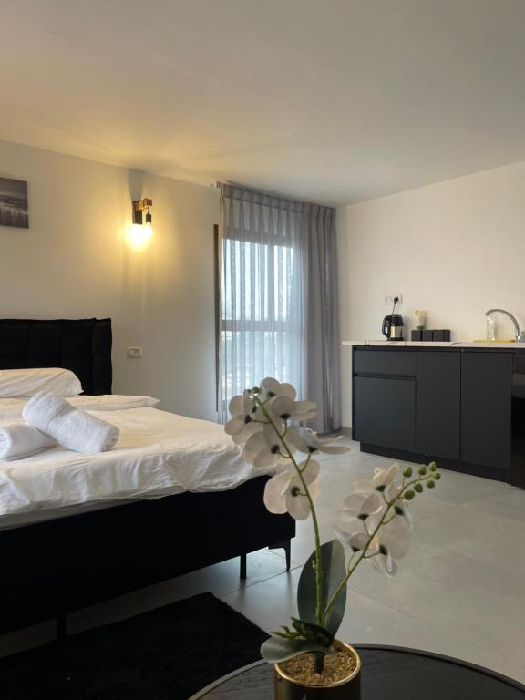 una habitación de hotel con una cama y un jarrón con flores en K.suites סוויטות בוטיק, en Beit She'an
