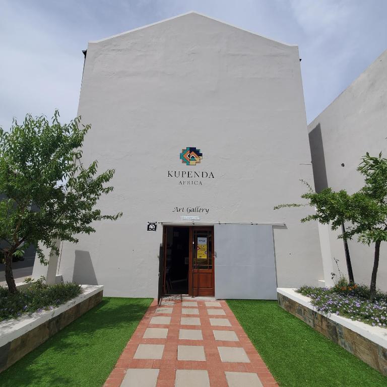 ein Eingang zu einem weißen Gebäude mit einer Tür in der Unterkunft Kupenda Africa in Montagu